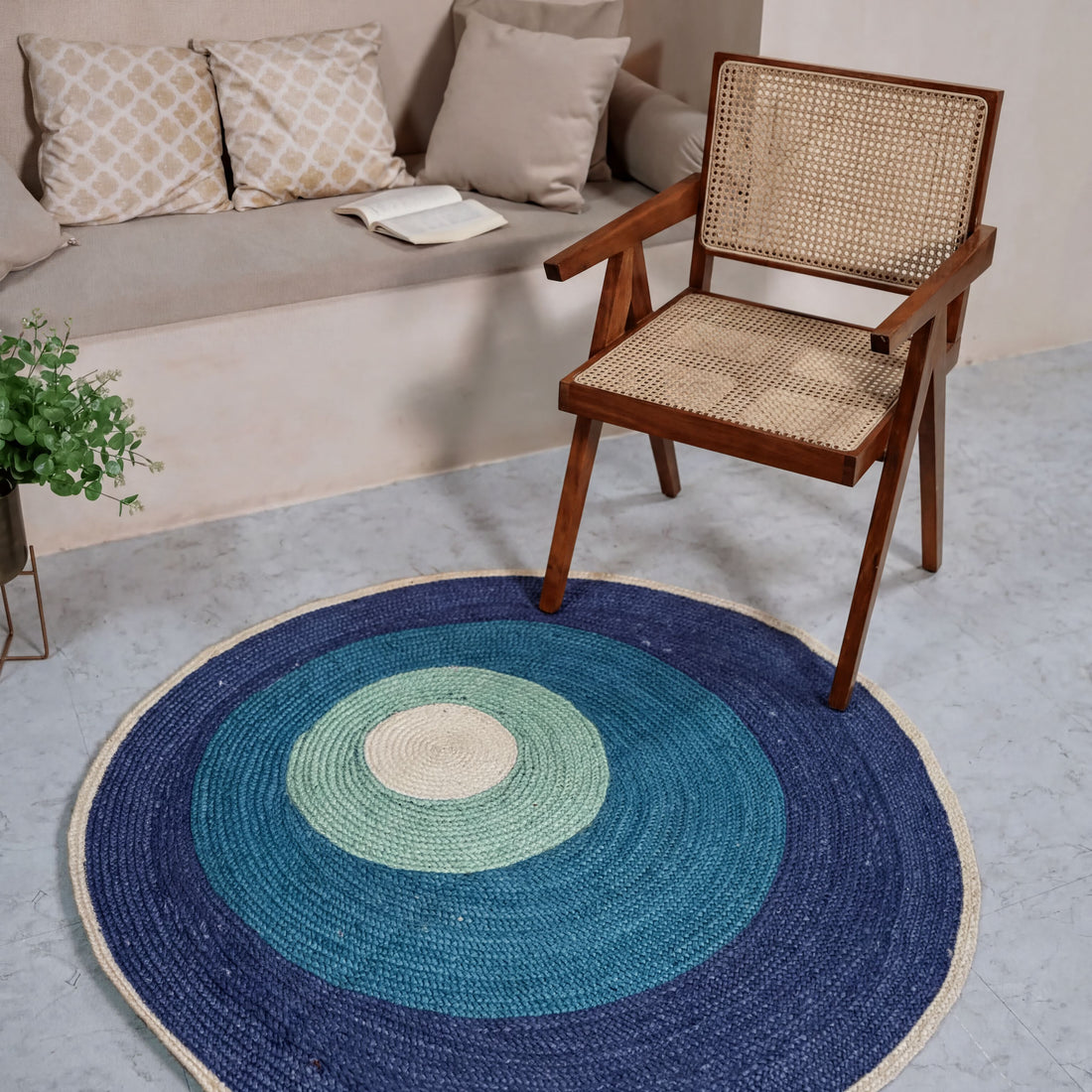 a wooden chair with a woven seat and backrest, placed on a blue and green circular rug in a living room setting.