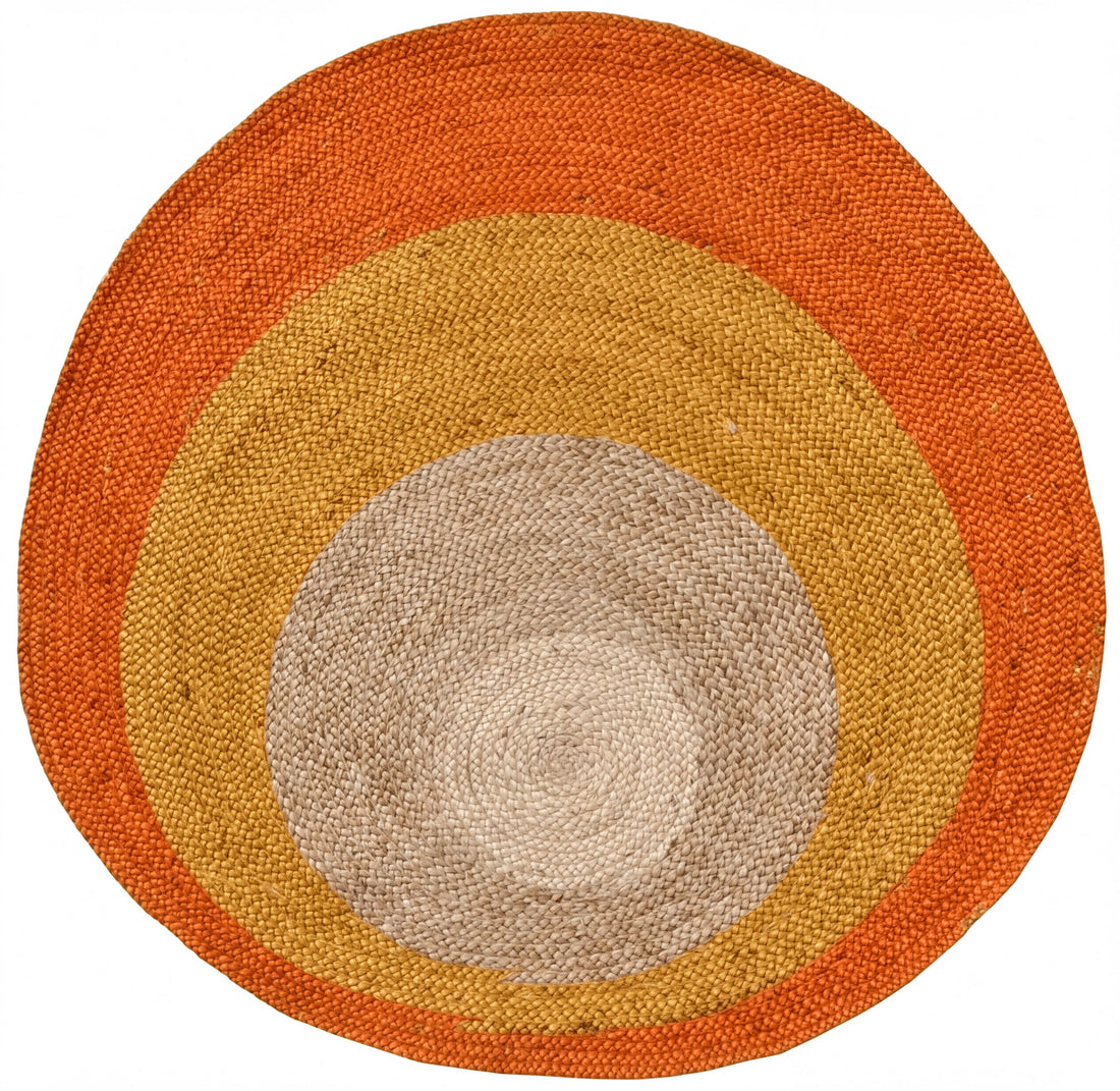 a circular rug with concentric circles of different colors, including orange, yellow, and gray.