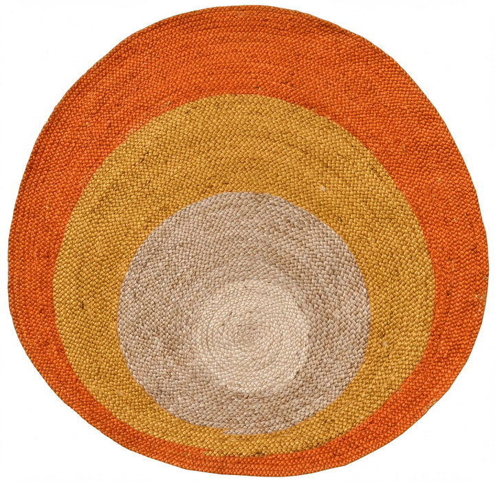 a circular rug with concentric circles of different colors, including orange, yellow, and gray.